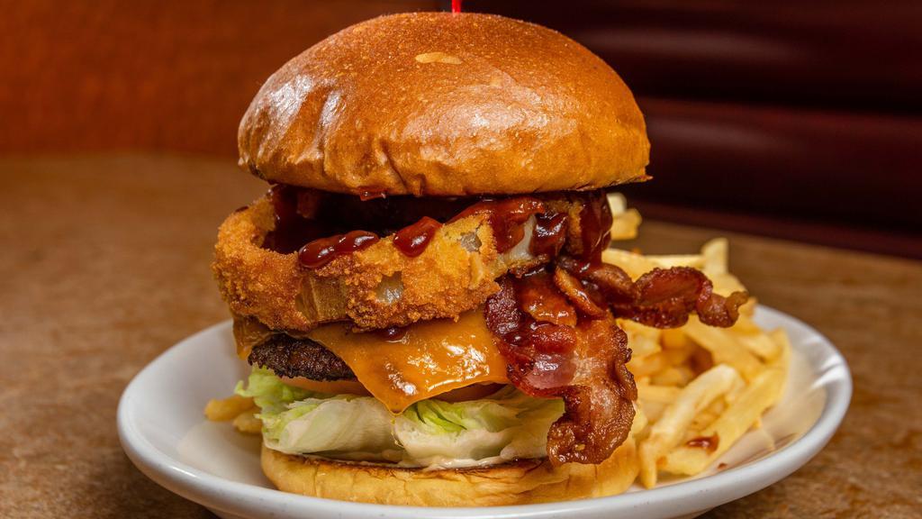 The Hickory Burger · Two slices of melted Cheddar cheese, with thick-cut bacon, crisp lettuce, tomato, RubySauce, and crispy RubyRings, all topped with zesty BBQ sauce.