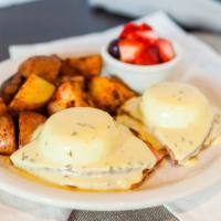 Eggs Benedict · Two poached eggs with smoked ham, topped with our creamy Hollandaise sauce, over a grilled e...