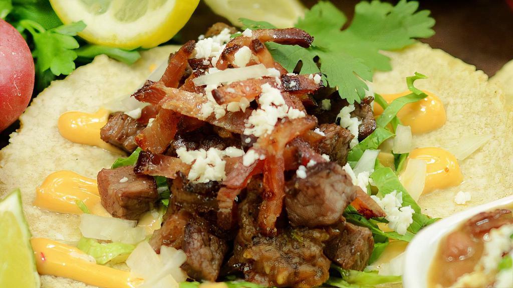 Steak & Bacon Tacos · housemade corn tortillas, chipotle aioli, seared steak, chopped bacon, onions, lettuce, salsa & queso fresca | gff