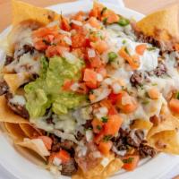 Nachos · With crunchy corn tortilla chips, option of meat, refried beans, cheese, pico de gallo, guac...