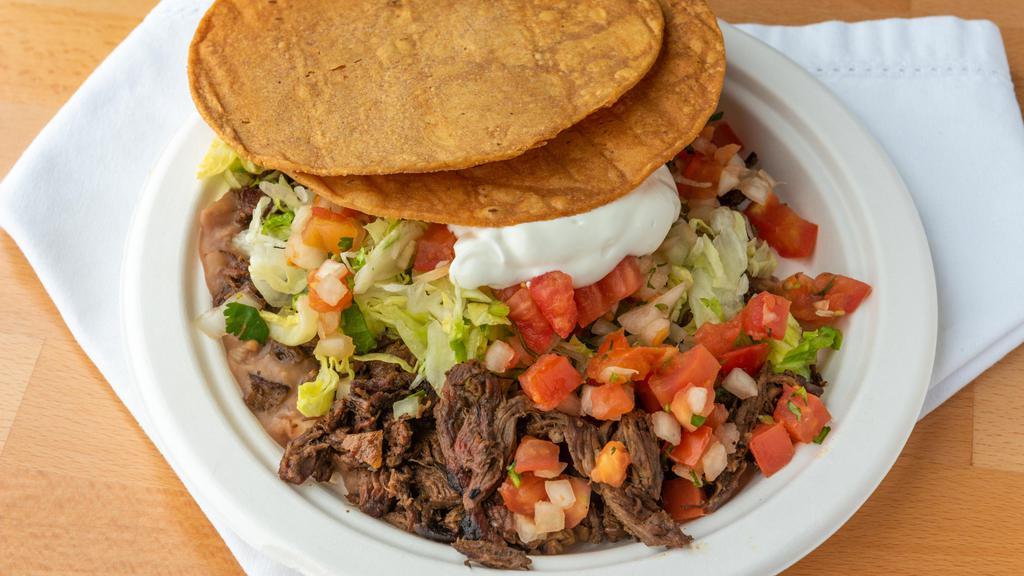Tostada · With meat, refried beans, lettuce, pico de gallo and sour cream.