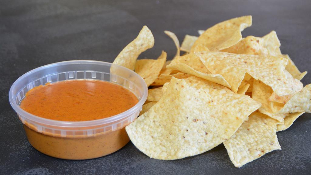 Chips & Queso · Melted queso sauce with a perfect blend of Mexican spices served with crispy corn tortilla chips.