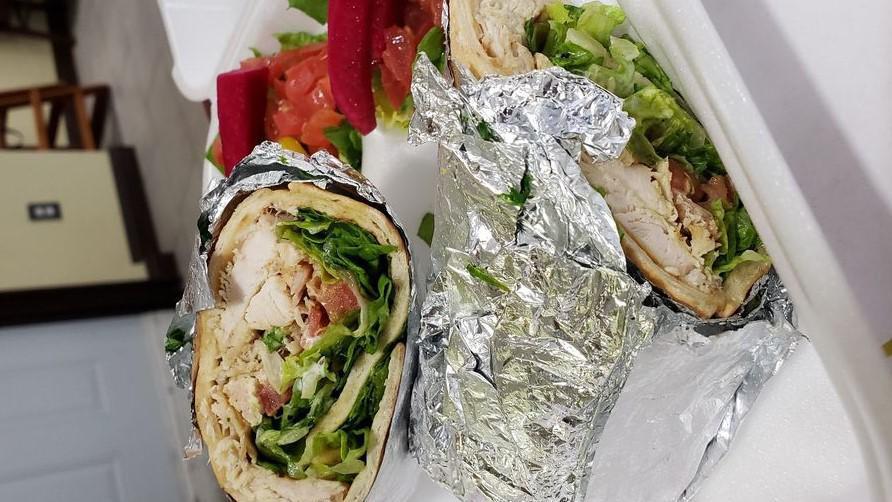 Chicken Shawerma Wrap · Marinated chicken shawerma strips wrapped in pita bread with tomatoes, lettuce, onion and garlic sauce.