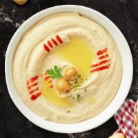 Hummus  · Pureed chickpeas topped with paprika and olive oil. Served with a freshly baked bread.