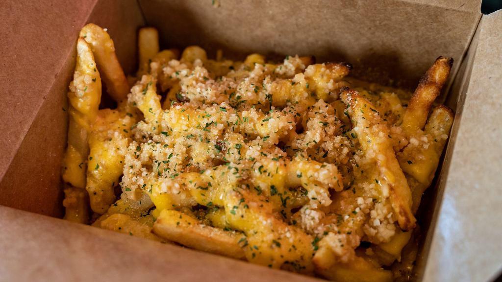 Garlic Fries · Fresh and crispy shoestring French fries with fresh garlic cloves and parmesan sauce drizzled on top .