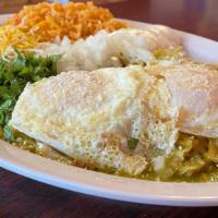 Chilaquiles Rojos O Verdes · Tortilla strips with eggs, sauce and sour cream on the side.