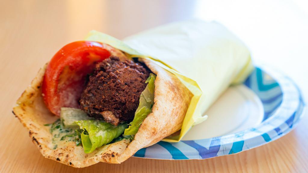 Falafel · Vegetarian sandwich of falafel with Romaine lettuce, tomatoes, Hummus, & pickles in pita bread & topped with tahini sauce.