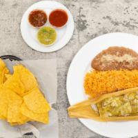 Tamale · Chile Verde tamale with chunks of tender pork with cheese on top
