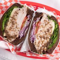 Sherron Tasty Turkey · Squaw bread, golden turkey, Swiss cheese, spinach, tomato, cucumber, red onion, pickles, may...