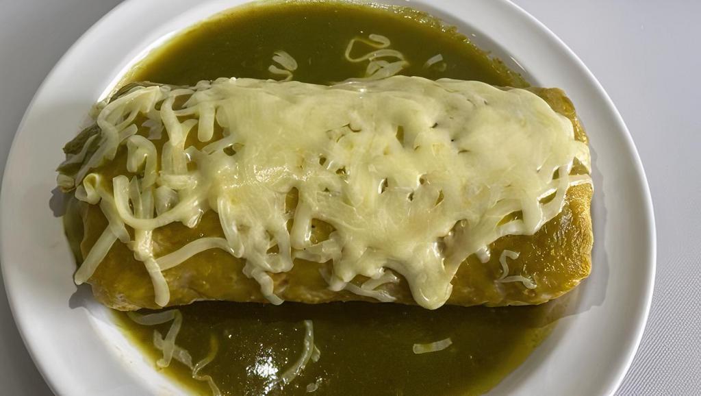 Burrito Bañado Super · Meat, rice, whole beans, cheese, sour cream, guacamole, and pico salsa. Topped with red enchilada sauce and cheese.