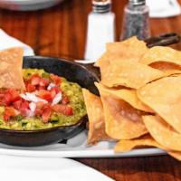Skillet Guacamole · Fresh guacamole folded with fire roasted tomato salsa served with thick tortilla chips.