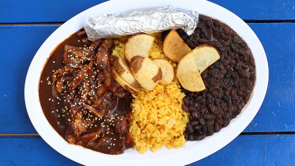 Mole Poblano · Shredded chicken smothered in delicious mole, served with spanish rice, black beans, and cuban ff.
