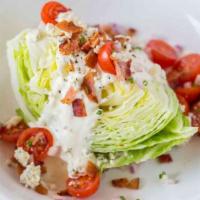 Hugo'S Wedge Salad · Crisp iceberg lettuce, sliced red onion, tomatoes, bacon crumbles, and bleu cheese dressing.