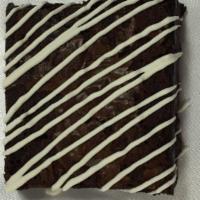 Plain Drizzle Brownie · Our chocolate brownie has semi-sweet chocolate chips baked in and then drizzled with white c...