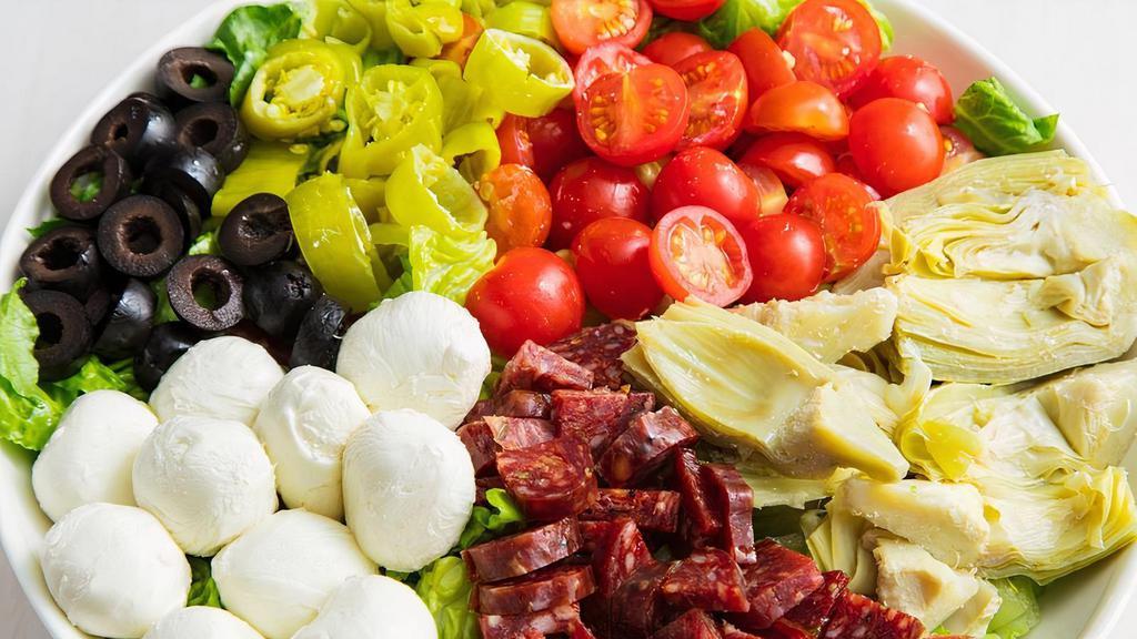 Wood Stone Antipasto · Mixed greens, salami, green & black olives, mozzarella cheese, artichoke hearts, ham, and pepperoncini peppers with Italian dressing.