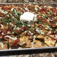 Nacho Party · Made-here corn tortilla chips topped with diced chicken, melted cheese, cilantro, Mexican ri...