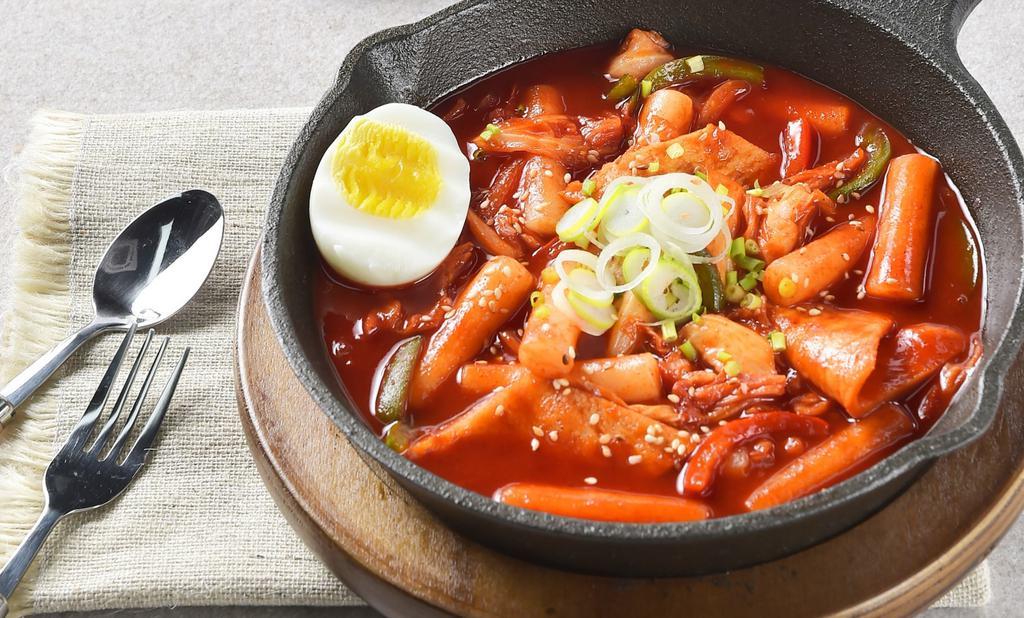 Dduk-Bokki  · Spicy with a hint of sweetness korean soup with Rice Cakes, Fish Cake, Cabbage, with half hard boiled egg. Garnished with scallions & sesame seeds