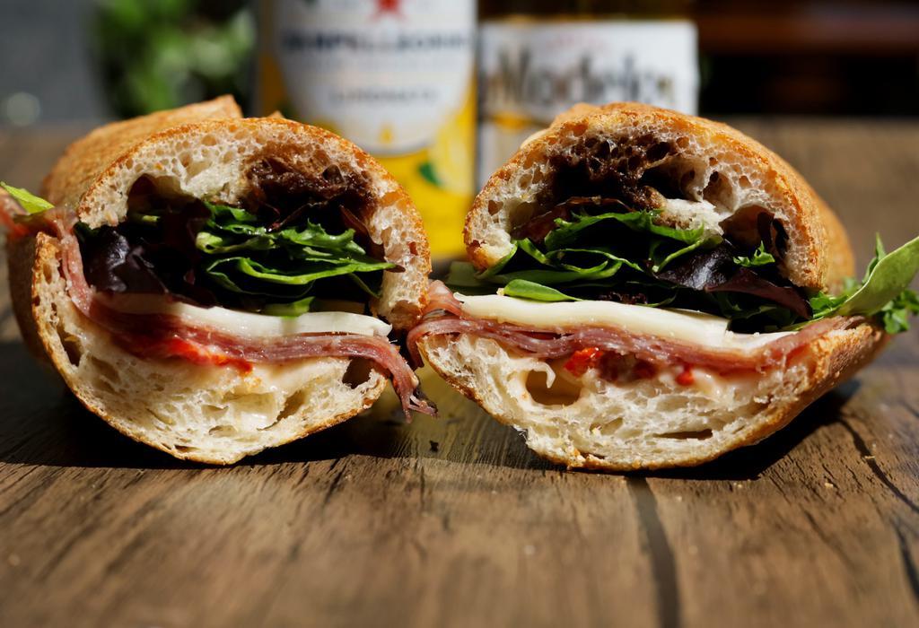 Milan Salami Sandwich · Our Italian Salami is served with Provolone Cheese, fresh Baby Mixed Greens, Virgin Olive Oil, Balsamic Vinegar, and our homemade Tomato Spread.