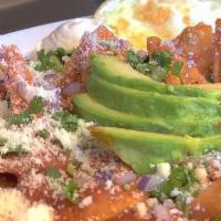 Chilaquiles Rojos (Red) · Made to order fried corn tortilla chips topped with our house red sauce, cotija cheese, red ...