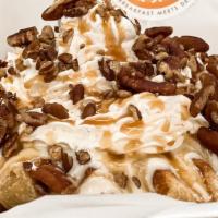 Salted Caramel Cheesecake · Cheesecake, salted caramel sauce, pecans, and whipped cream.