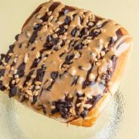Reese Stuff Candy Donut · Chocolate square donut with chocolate chip and peanuts. Peanut butter drizzle with Reese pea...
