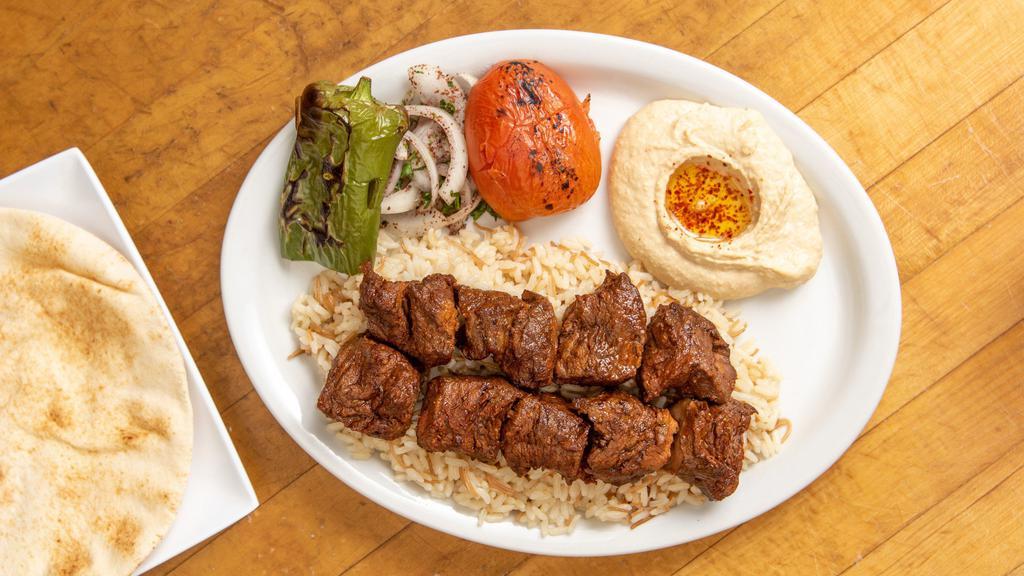 Shish Kebab · 2 skewers of filet mignon, rice, hummus, onions, grilled tomato, and pepper with pita bread.