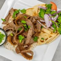 Traditional Gyros Plate · Thinly sliced beef and lamb gyros cooked on a rotisserie. Served on a bed rice with pita bre...