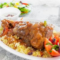 Lamb Shank · Bone-in lamb shank baked in a tomato, onion, cinnamon and nutmeg sauce. Served with Greek sa...