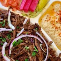 Beef Shawarma Plate · Served with rice, hummus, salad, onions and pita bread. Drizzled with tahini sauce.