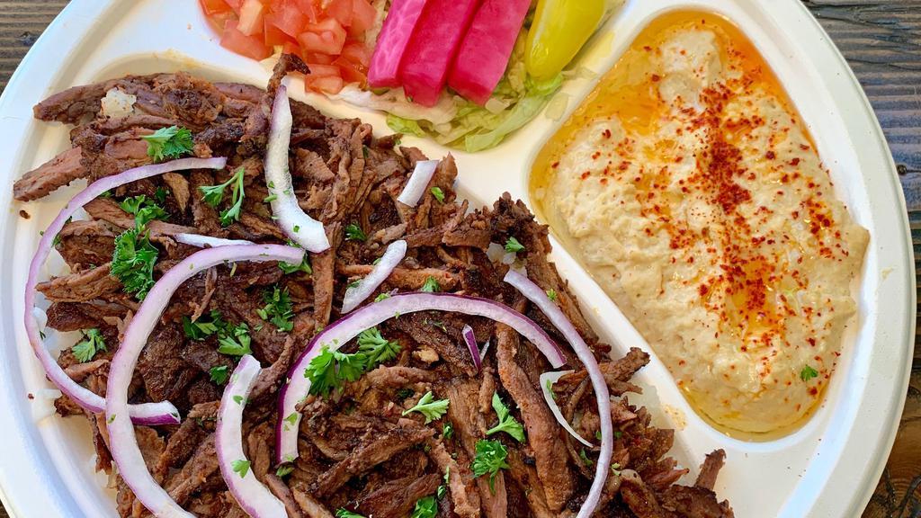 Beef Shawarma Plate · Served with rice, hummus, salad, onions and pita bread. Drizzled with tahini sauce.