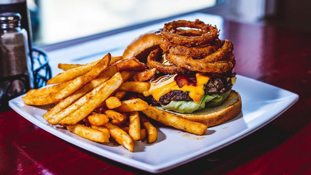 Bacon Cheese Burger · 1/2 pound cattleman's Selection fresh Pattie , smoked bacon, American cheese, lettuce, onions, tomato, topped off with our signature sauces (bbq and patron). Choose our coated French fries or signature side salad.