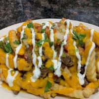 Asada Fries · French fries with nacho cheese, meat of your choice topped of with pico de gallo and sour cr...