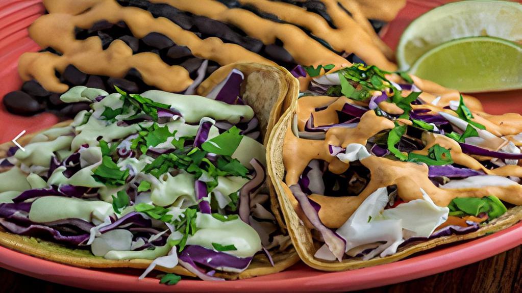 Taco Plate (V) · Two tacos with guacamole, cabbage, & Cilantro Lime Crema on corn tortillas with your choice of fillings (see options below). Served with a side of black beans, brown rice & salsa with a Chipotle sauce drizzle.