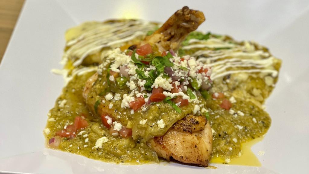 Pollo Verde Y Enchilada · Pan seared bone-in chicken breast with verde cream sauce paired with an enchilada filled with queso and topped with roasted tomatillo suiza sauce and crema drizzle. Served with masehd black beans, sweet corncake and choice of cilantro rice, tangy coleslaw or cantina corn.