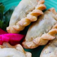 Sanbousek · Fried ground beef pies stuffed with onion and pine nuts.