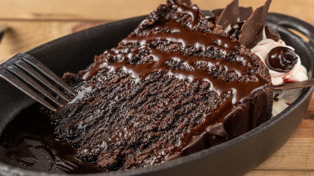 Decadent Chocolate Cake · Chocolate cake, filled with rich milk chocolate ganache, chocolate sauce, whipped cream, amarena cherries, chocolate shavings