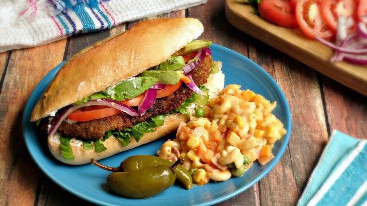 Tort Milanesa · Breaded meat, beans, tomato, lettuce, two types of cheese and grilled onions.