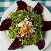 Beet Salad · Arugula, walnuts goat cheese in a red wine reduction dressing.