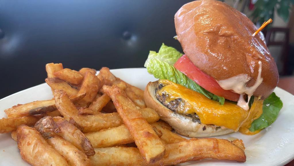 Cheeseburger · One-third pound grilled black angus beef patty, topped with melted cheddar cheese, vine-ripened tomatoes, lettuce, pickles, sweet red onions and thousand island dressing on a soft artisan bun.