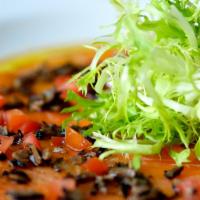 Salmon Carpaccio · with black truffles, diced tomatoes, frisee, ginger soy vinaigrette, and truffle oil