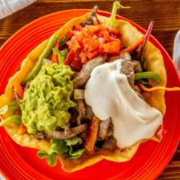 Fajita Salad · Grilled beef or chicken on mixed greens with tomatoes, salsa, sour cream & guacamole in a to...