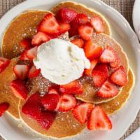 Strawberry Pancakes · Buttermilk pancakes topped with freshly cut strawberries and whipped cream. Served with stra...