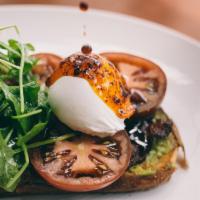 Blt Avocado Toast · Grilled sourdough bread, forked avocado, sliced heirloom tomato, poached egg, spicy red chil...