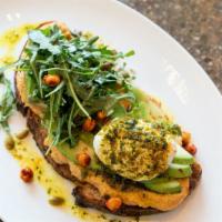 Mediterranean Avocado Toast · Grilled whole wheat bread with avocado, hummus, poached egg, za'atar-infused EVOO, crispy ch...