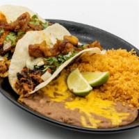 Tacos Al Pastor (2) · Two flour tortillas filled with our guajillo and ancho chile, citrus marinated diced pork to...