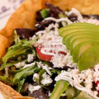 Tostada Salad · A tostada bowl filled with spring mixed greens, tomato, white rice, black beans, sour cream,...