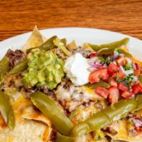 Nachos · Your choice of meats: Asada, chicken, pastor, or carnitas. With beans, cheese and our specia...