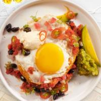 Huevos Rancheros · Lightly fried eggs served on a fried corn tortilla topped with homemade red salsa, queso fre...