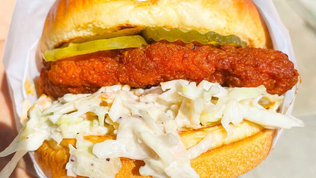 Nashville Style Crispy Fried Chicken Sandwich · crispy fried chik'n sandwich drenched in Nashville style hot sauce with slaw, pickles, and honey mustard.