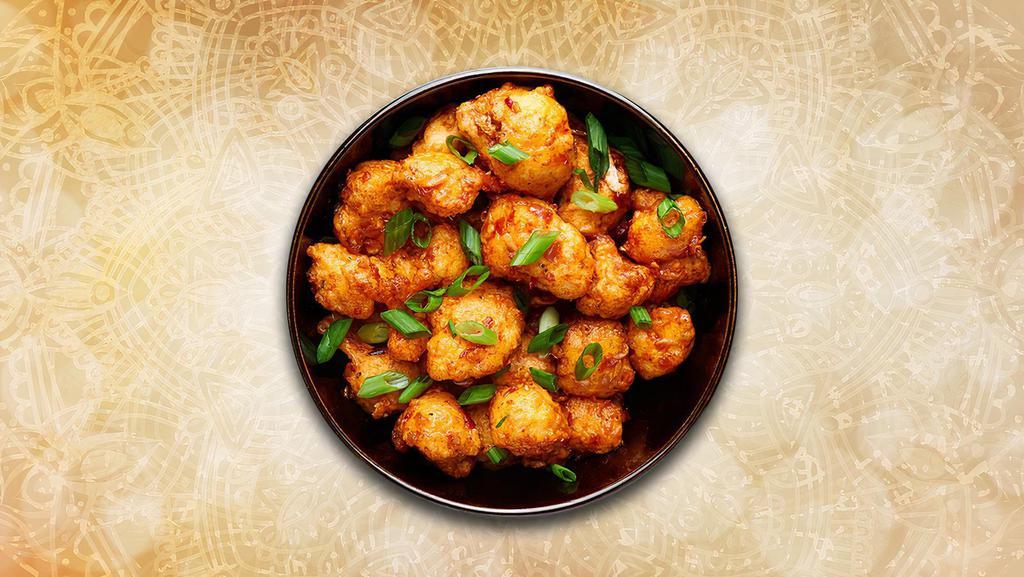 Cauliflower Manchurian · Crispy fried cauliflower florets are tossed in a spicy sauce with green onions and an Indo-Chinese Manchurian sauce